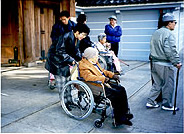 神社から車椅子を押して出てくる女性の写真