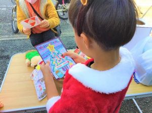 クリスマスカードを読む子供の画像